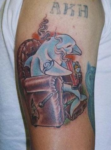 Цветная тату на плече в виде дельфина в кресле