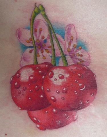 Цветная тату на животе девушки в виде цветков и ягод сакуры