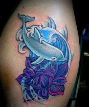 Цветная тату в виде дельфина с цветком на плече