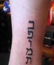 Тату - надпись на иврите на запястье у девушки