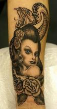Татуировка змеи на голове девушки - на руке